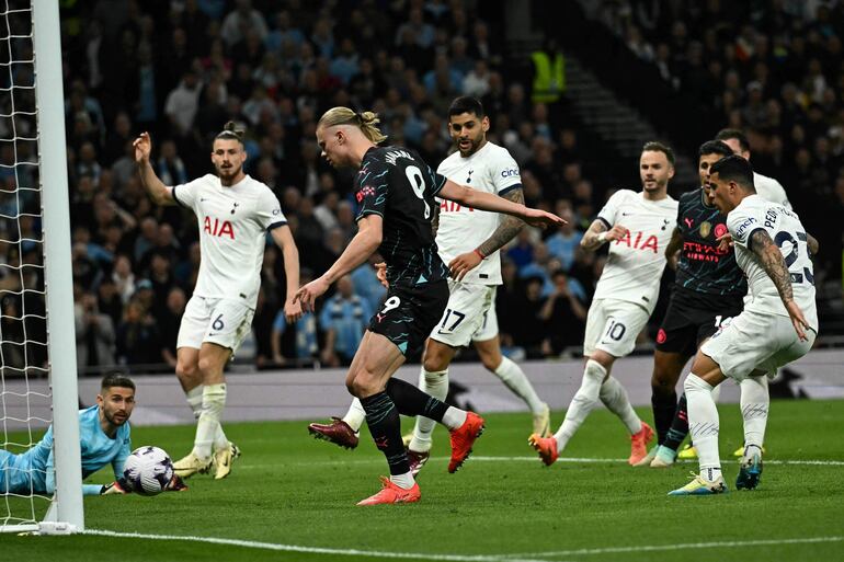 Manchester City's Norwegian striker #09 Erling Haaland (C) shoots and scores his team first goal during the English Premier League football match between Tottenham Hotspur and Manchester City at the Tottenham Hotspur Stadium in London, on May 14, 2024. (Photo by Ben Stansall / AFP) / RESTRICTED TO EDITORIAL USE. No use with unauthorized audio, video, data, fixture lists, club/league logos or 'live' services. Online in-match use limited to 120 images. An additional 40 images may be used in extra time. No video emulation. Social media in-match use limited to 120 images. An additional 40 images may be used in extra time. No use in betting publications, games or single club/league/player publications. / 