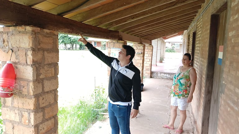 El profesor Heber López muestra la madera carcomida por termitas en el local de la escuela y colegio San Rafael de la compañía Ykua Rugua del distrito de San José de los Arroyos.  