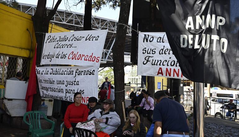 Los exfuncionarios permanecen al costado del portón de acceso de la ANNP del puente de la Amistad.