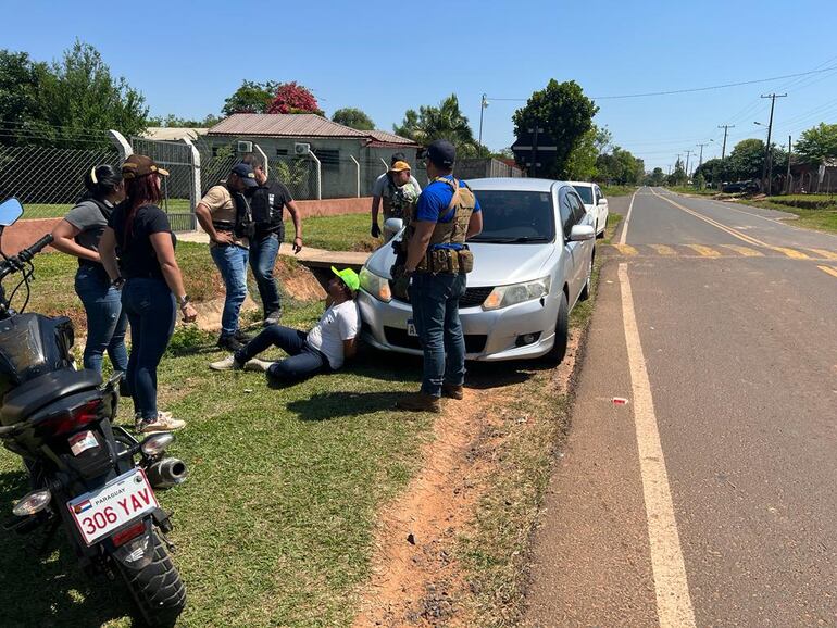 Agentes de la Senad custodian a los detenidos en Yby Pytã, tras el hallazgo del cargamento de marihuana prensada distribuido en tres vehículos.