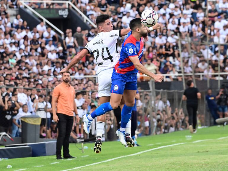 Brian Montenegro (24), delantero de Olimpia, salta con Daniel Rivas, defensor de Cerro Porteño, durante el superclásico del fútbol paraguayo por la sexta fecha del torneo Apertura 2023 en el estadio Manuel Ferreira de la ciudad de Asunción.