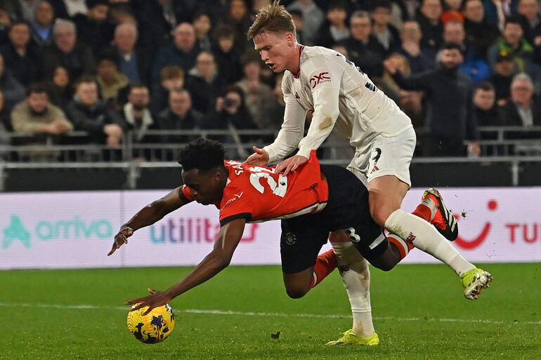 Albert Sambi Lokonga, mediocampista belga del Luton Town, queda en una posición incómoda ante Scott McTominay, mediocampista escocés del Manchestes United.