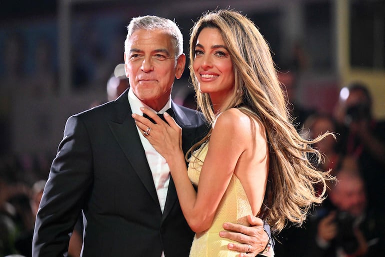 El actor George Clooney y su esposa Amal Clooney, muy enamorados en la alfombra roja de la película "Wolfs" presentada fuera de competición durante el 81º Festival Internacional de Cine de Venecia, en el Lido de Venecia. (Alberto PIZZOLI / AFP)