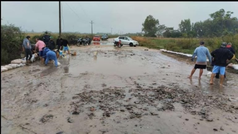 En Tacuaras, a metros del campamento del MOPC, pobladores realizan muros de contención con bolsas de arena para impedir que las aguas inunden el camino.