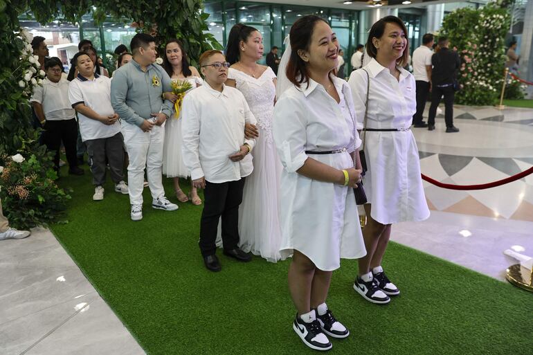 Las parejas participantes esperan para entrar en una sala de recepción para una ceremonia masiva de compromiso LGBTQIA+ para conmemorar el día de San Valentín en Quezon City, Metro Manila, Filipinas