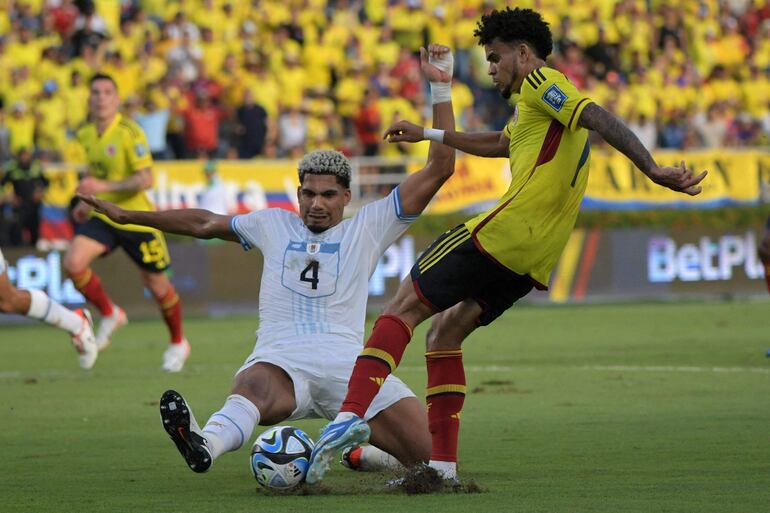 El defensor charrúa, Ronald Araújo intenta bloquear el disparo del atacante colombiano Luis Diaz. (Foto: AFP)