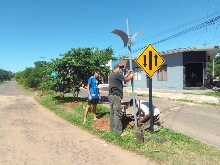 Los vecinos de una sector de la calle principal están en plena tarea de la colocación de los postes para la iluminación