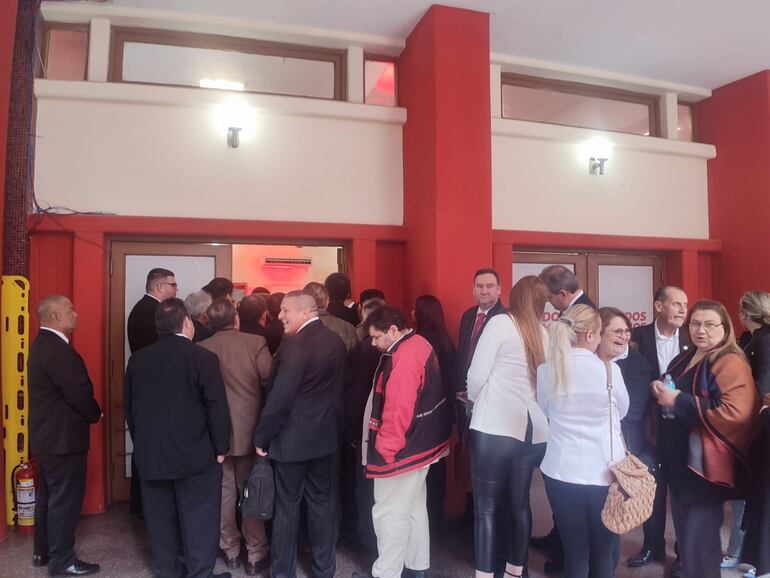 Hurreros colorados aguardan su turno frente ala entrada a la sede de la ANR para saludar a Cartes.