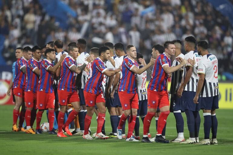 Los jugadores de Alianza Lima (d) y de Cerro Porteño en el saludo previo al partido por la fase de grupos de la Copa Libertadores 2024 en el estadio Alejandro Villanueva, en Lima, Perú.