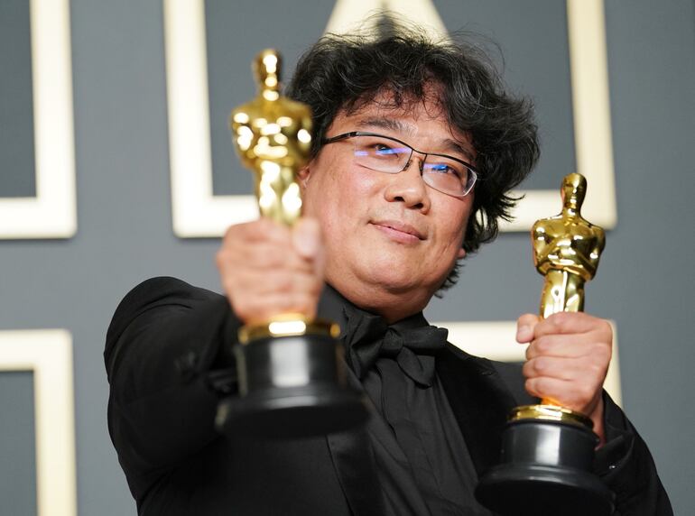 El cineasta surcoreano Bong Joon-ho posa con dos de las cuatros estatuillas conseguidas por su película “Parásitos”, durante la 92° entrega de los Premios Óscar.