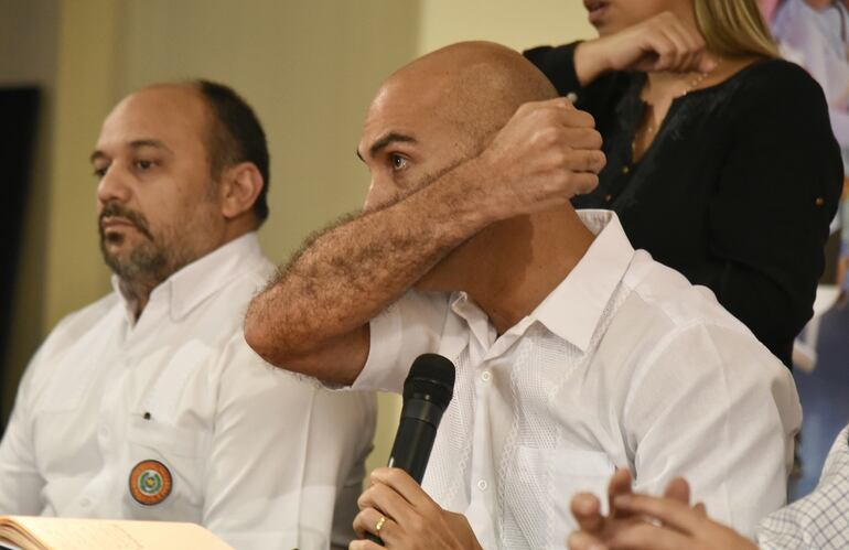 El ministro de Salud Pública, Julio Mazzoleni, muestra la forma correcta en que un paciente debe toser (llevar la flexura del codo hacia la boca) para evitar contagios. Fue en conferencia de prensa en la que se divulgó el primer caso de coronavirus en el país, un hombre de 32 años que actualmente se encuentra bien.