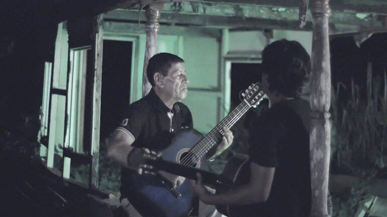 Rosalino Zárate, músico de Lima, con Juan Vera (de espaldas) en una escena de La afinación del diablo (2018), de Juanca Lucas