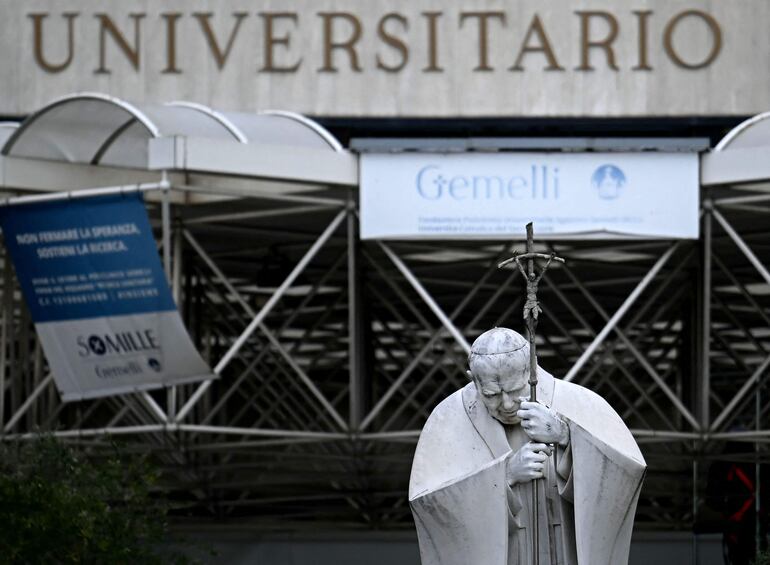 Esta fotografía muestra una vista de la estatua del Papa Juan Pablo II afuera del hospital Gemelli donde el Papa Francisco está hospitalizado para pruebas y tratamiento por bronquitis en Roma.