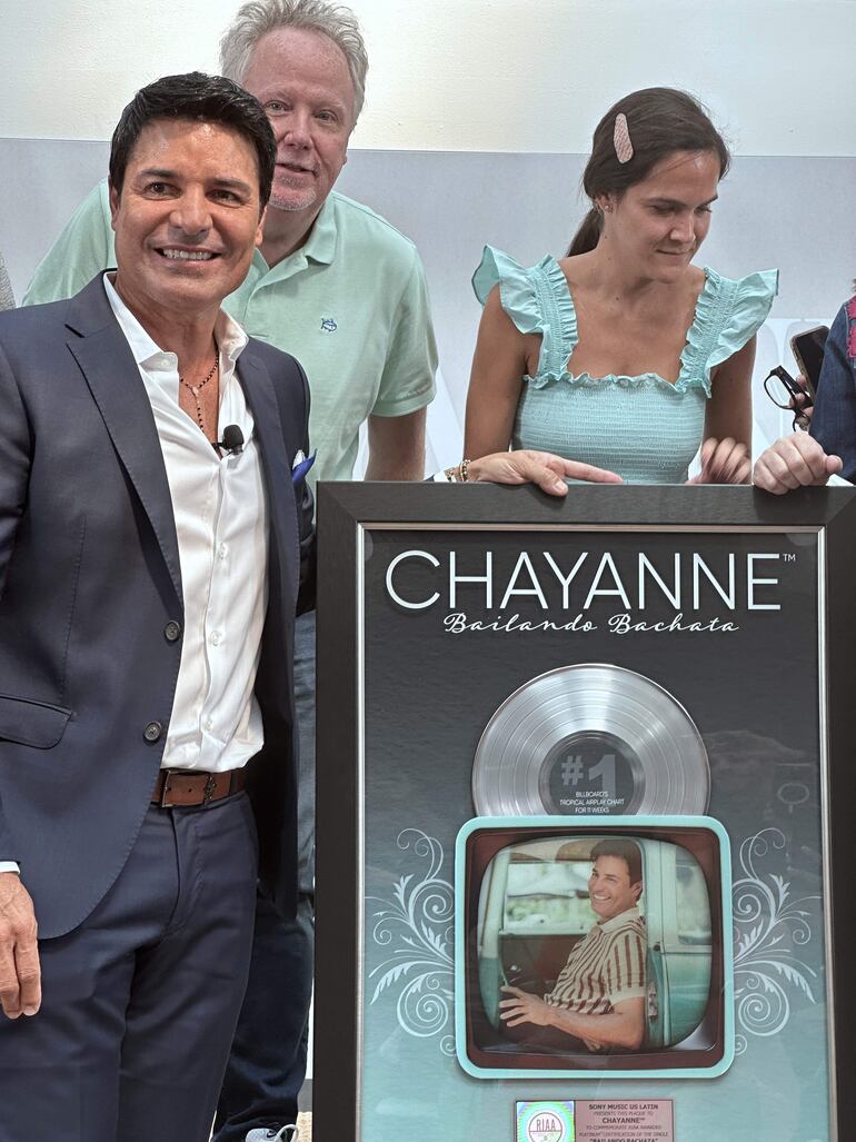 El cantante puertorriqueño Chayanne posa con su placa del número 1 de la lista de Billboard Tropical por su canción "Bailando Bachata", junto al vicepresidente de ventas y marketing del catálogo original de Sony Music, Gregg Vickery (arriba), y la directora asociada de marketing internacional de Sony Music, Alejandra García, en Miami, Florida (EE.UU). 