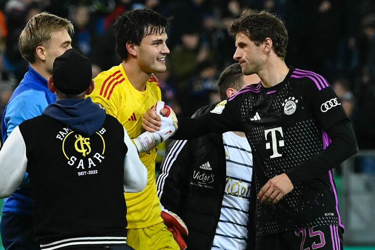 Thomas Müller (d), del Bayern Munich, congratular al arquero del Saarbruecken, Tim Schreiber, al final del partido que el gigante alemán perdió sorpresivamente.