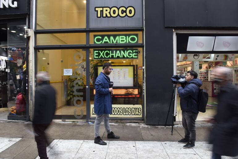 Transeúntes caminan afuera de una casa de cambio, en Buenos Aires (Argentina). En un contexto de alta incertidumbre política y económica y mientras la ministra de Economía argentina, Silvina Batakis, se encuentra en EE.UU. para conversar con el Fondo Monetario Internacional (FMI). (EFE)