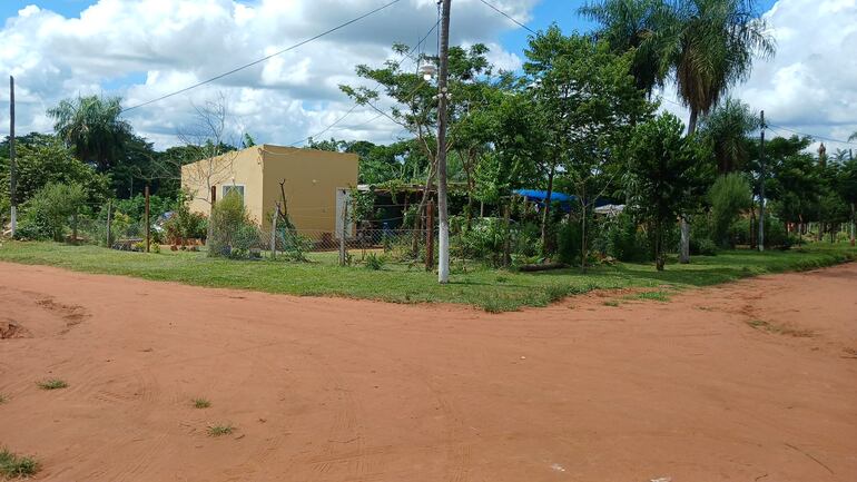 calle de arena y en la esquina una casa amarilla