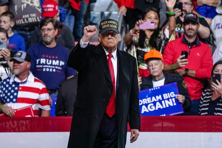 El expresidente de Estados Unidos y candidato presidencial republicano Donald Trump levanta el puño después de hablar al final de un mitin de campaña en el Anfiteatro Atrium Health en Macon, Georgia.