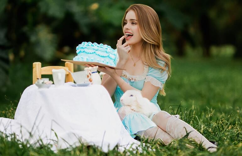 La cumpleañera Gaby Ovelar posando con tu torta y el tierno conejito blanco.