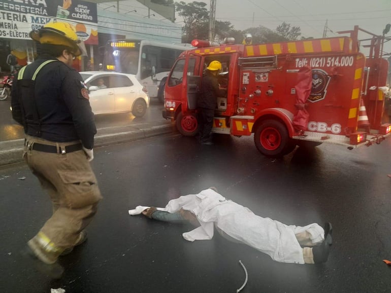 Un bombero observa el cuerpo sin vida de la mujer que fue arrollada sobre la ruta PY01, en zona de Fernando de la Mora.