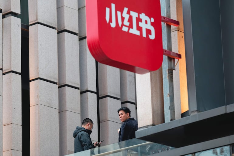 Los empleados están de pie en el balcón del edificio de la sede de la empresa Xiaohongshu (Pequeño Libro Rojo), también conocida como 'RedNote', en Shanghái, China.