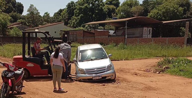 Una montacargas intenta recuperar el automóvil de la zanja creada en medio de la calle 12 de Octubre de San Juan Nepomuceno.