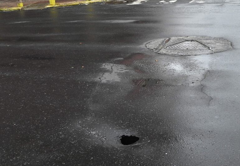 Agujero que se forma en medio de una aparente grieta sobre la calle Azara esquina Yegros de la capital.