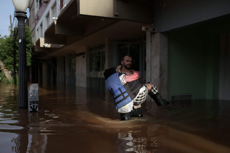 Un voluntario asiste a una víctima de las inundaciones en Porto Alegre, Río Grande do Sul, Brazil.