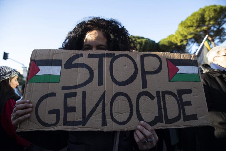 Rome (Italy), 13/01/2024.- A protester holds a placard during the demonstration of the Palestinian Student Movement in Italy "Stop the genocide of the Palestinian people" to demand an end to the conflict in Gaza, in Rome, Italy, 13 January 2024. Thousands of Israelis and Palestinians have been killed since the militant group Hamas launched an unprecedented attack on Israel from the Gaza Strip on 07 October, and the Israeli strikes on the Palestinian enclave which followed it. (Protestas, Italia, Roma) EFE/EPA/ANGELO CARCONI
