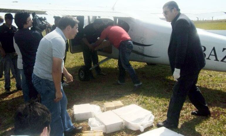 Policías sacan bolsas con drogas de la avioneta que pilotaba Juan Papacho Domingo Viveros Cartes.