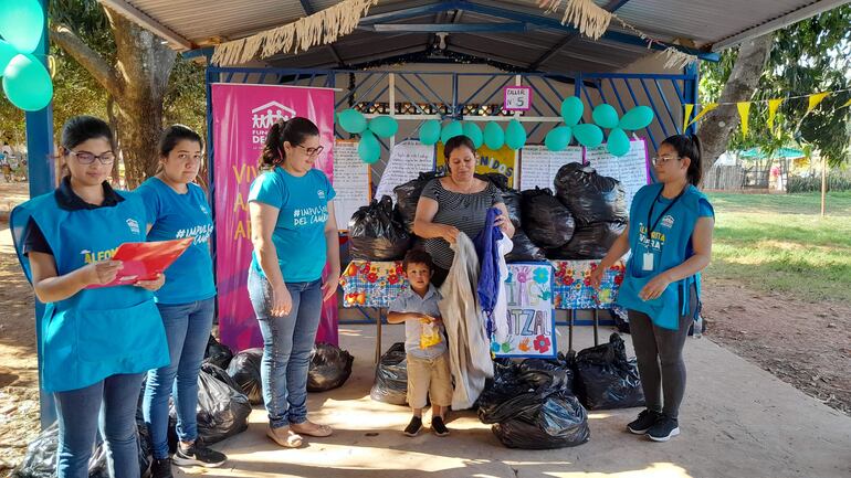 Momento de la entrega de las prendas de vestir a las familias del asentamiento Mandarinal de la ciudad de Ypané.