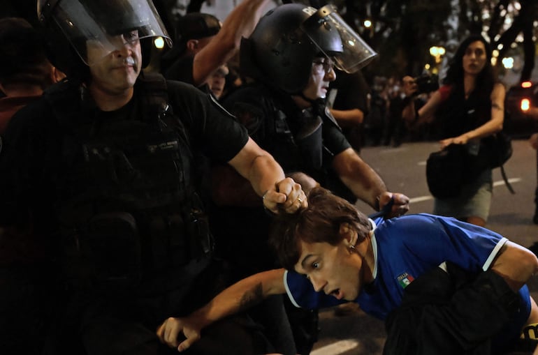 La policía estira del cabello a un hombre durante la protesta contra los recortes al cine argentino.