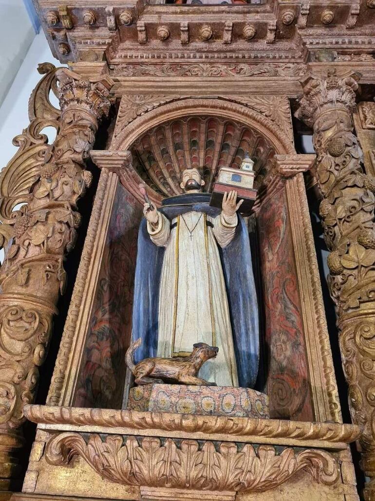 Una imagen detallada del Santo Domingo de Guzmán que se encuentra con su perro a un costado del retablo histórico de la Iglesia de Caazapá. 