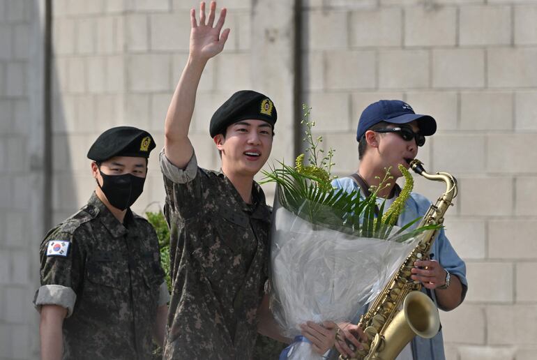 Jin (en el centro), junto a sus compañeros de BTS Jimin (a la izquierda) y RM, sale de la base militar en Yeoncheon, Corea del Sur, donde cumplió su servicio militar obligatorio.