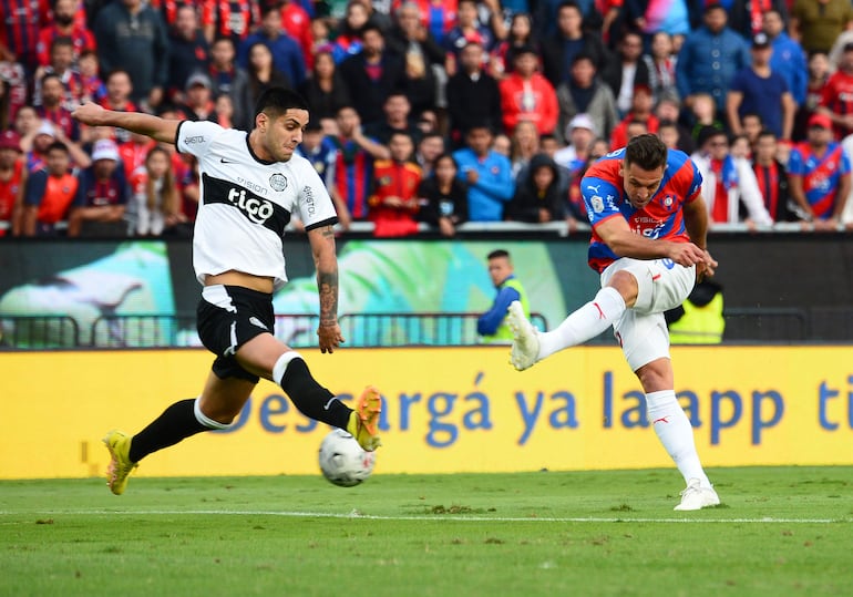 El argentino Diego Churín (d), jugador de Cerro Porteño, lanza el balón en el partido contra Olimpia el superclásico del fútbol paraguayo en el estadio Pablo Rojas, en Asunción, Paraguay.