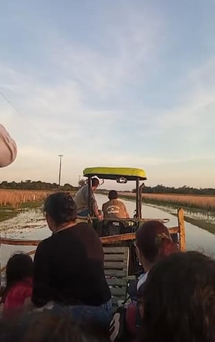 Pobladores de Duarte Cué y Tacuara´i distrito de Tacuaras viajan en un Cachape estirado por un tractor, desafiando el pésimo estado del camino en busca de alimentos.