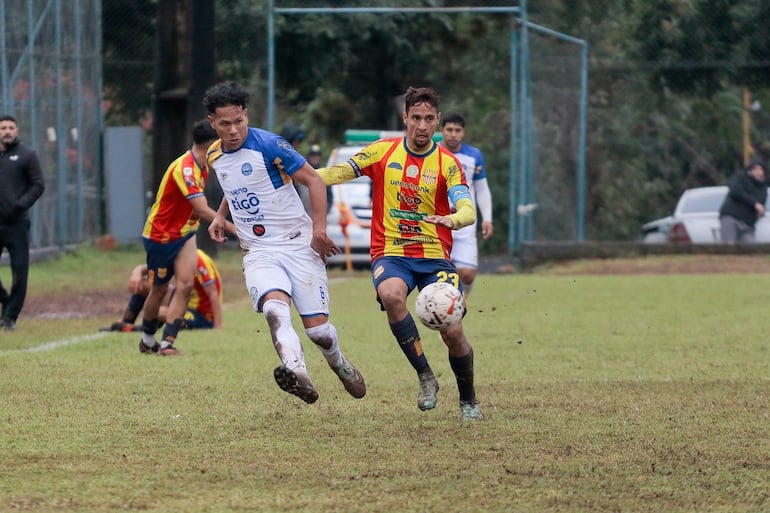 Rodrigo Resquín extiende el pase ante la presencia del capitán aurirrojo Juan José Martínez. (Foto: APF)