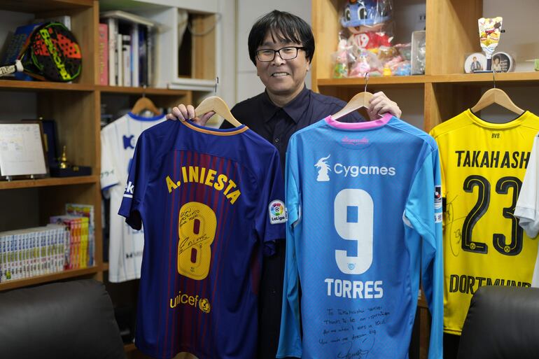 El artista de manga Yoichi Takahashi tiene camisetas firmadas por los futbolistas españoles Andrés Iniesta (L) y Fernando Torres durante una entrevista en su oficina de Tokio, Japón, el 22 de abril de 2024.