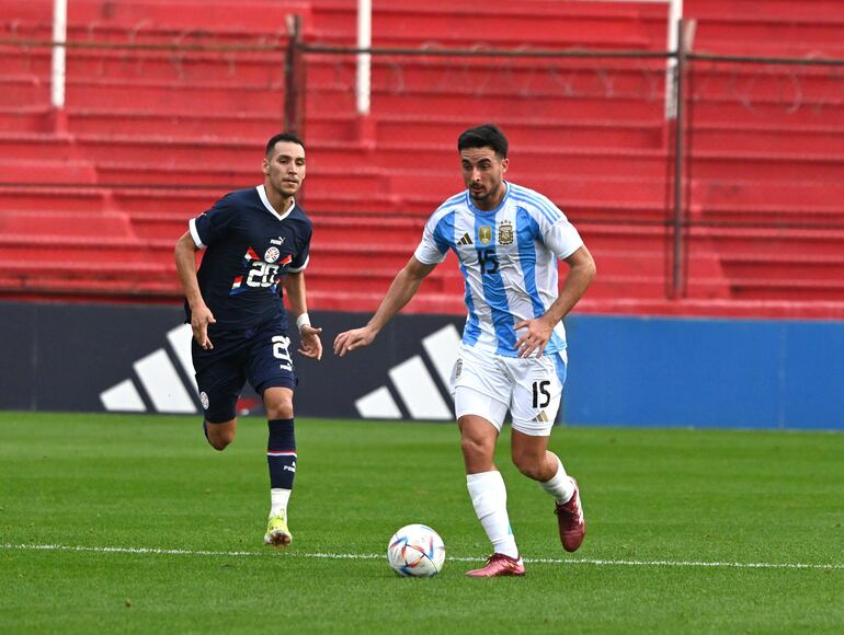 El delantero paraguayo Marcelo Fernández corre al central argentino Luján.