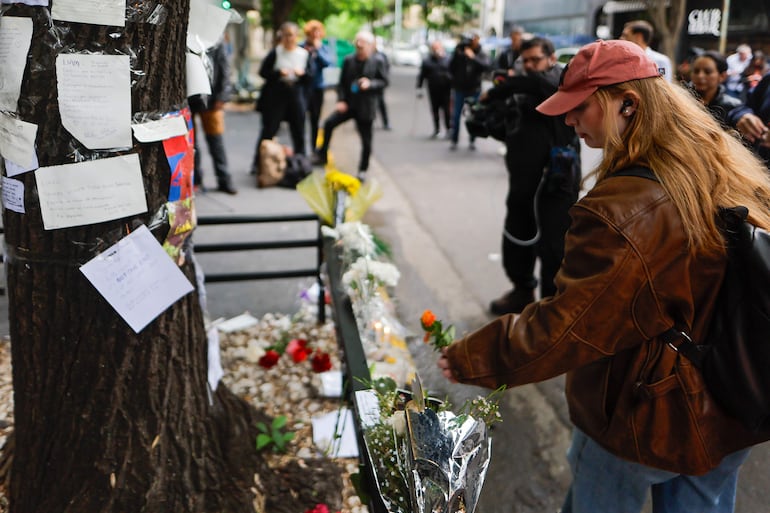 Una mujer coloca flores frente al hotel donde falleció el exintegrante de la banda One Direction, Liam Payne, este jueves, en la ciudad de Buenos Aires (Argentina). 