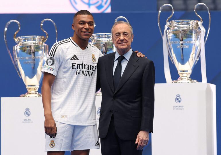 El jugador francés Kylian Mbappé (i) y el presidente Florentino Pérez en la presentación como jugador del Real Madrid en el estadio Santiago Bernabéu, en Madrid, España. 