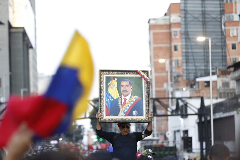 Un partidario del presidente venezolano, Nicolás Maduro, sostiene un retrato de Maduro durante una manifestación que respalda los resultados de las elecciones presidenciales en Caracas el 3 de agosto de 2024.