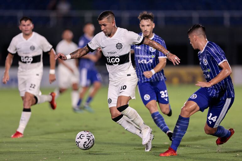 Derlis González, de Olimpia, ante la marca de los jugadores de Sol de América, Fernando Díaz (d) y Ever Cáceres (fondo).