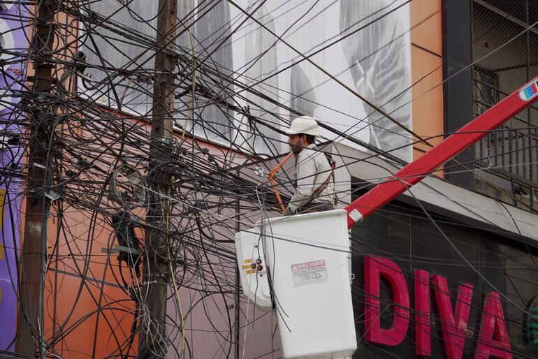 Técnicos de la ANDE proceden a retirar la maraña de cables del tendido eléctrico.