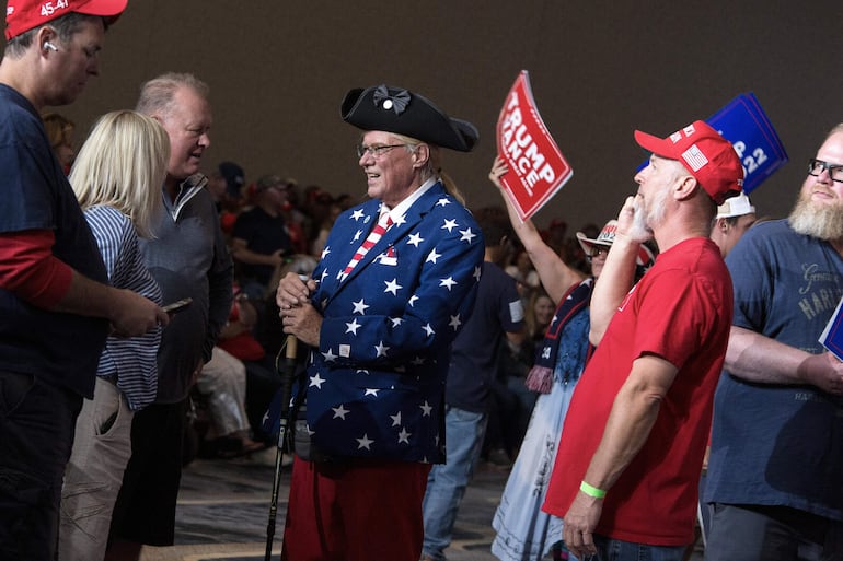 Los partidarios del ex presidente estadounidense y actual candidato presidencial republicano Donald Trump conversan mientras asisten a su mitin de campaña en Gaylord Rockies and Resort en Aurora, Colorado, EE.UU.