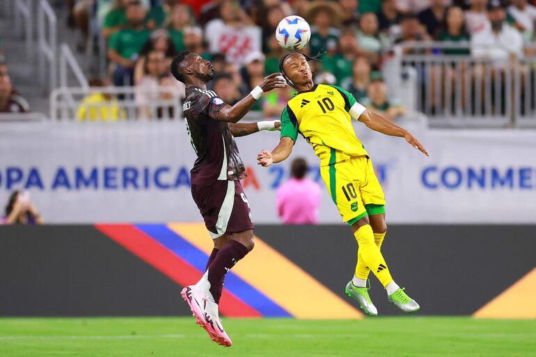 Bobby Decordova-Reid disputa por el balón con Julián Quiñones.