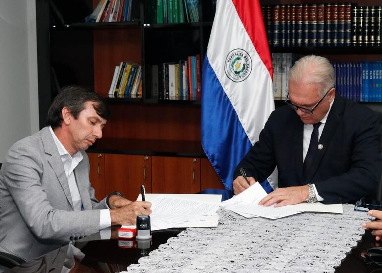 Momento en que el intendente de Cerrito, Hugo Ayala, y el fiscal general del Estado, Emiliano Rolón, firman el convenio de cooperación interinstitucional.