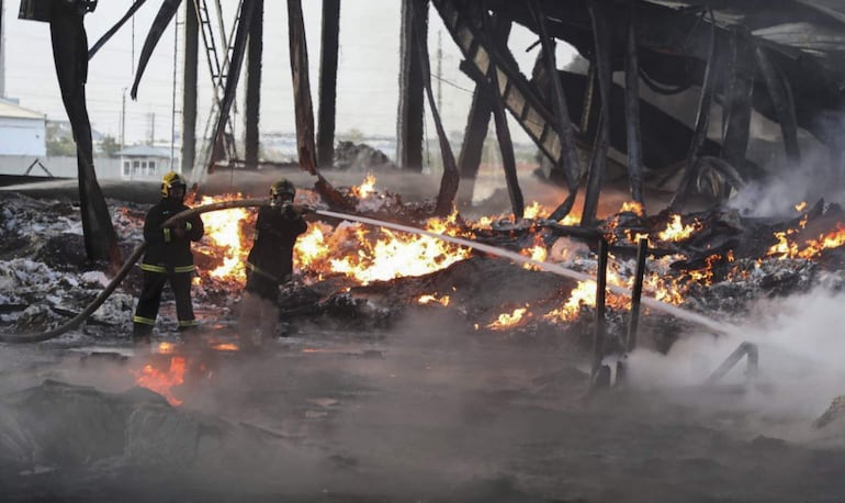 Una fotografía proporcionada por el Gobierno de Uzbekistán muestra a los bomberos uzbekos extinguiendo llamas en el lugar de una explosión en un almacén en Tashkent, Uzbekistán.