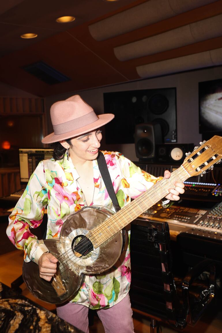 Emily Estefan prueba la guitarra elaboradas a partir de latas de dulce de batata.