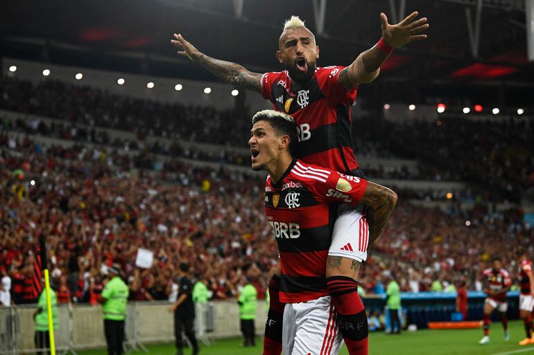 El delantero de Flamengo Pedro (L) celebra con el mediocampista chileno Arturo Vidal de Flamengo después de que el portero uruguayo Nicola Pérez (fuera del campo) de Ñublense anotó un gol en propia puerta durante el partido de ida del partido de la fase de grupos Libertadores entre Flamengo y Ñublense en el estadio Maracaná de Río de Janeiro. , Brasil, el 19 de abril de 2023.